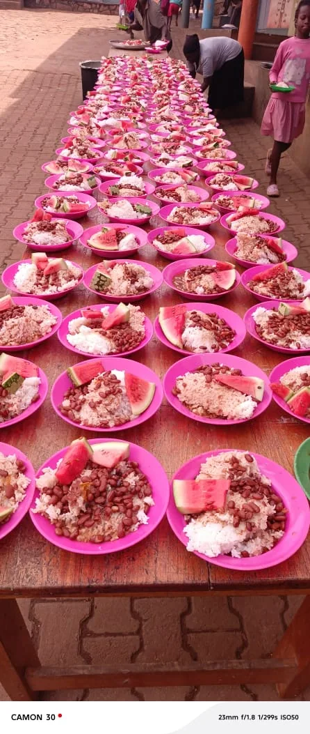 Rows of pink plates prepared with rice, beans, and fruit at school