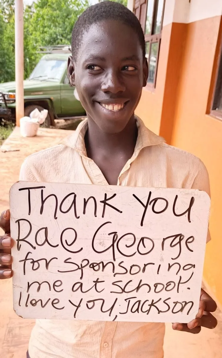 Jackson smiling with a handwritten thank-you note to Rae George